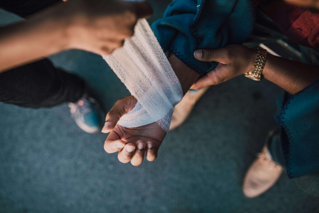 Person receiving help with bandaging an injured wrist, illustrating what to expect in a personal injury case.