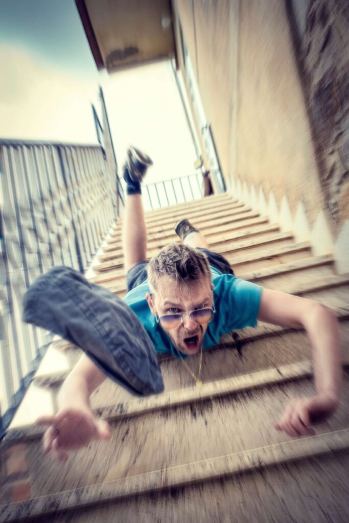 Man falling down stairs, demonstrating common causes of slip and fall accidents.